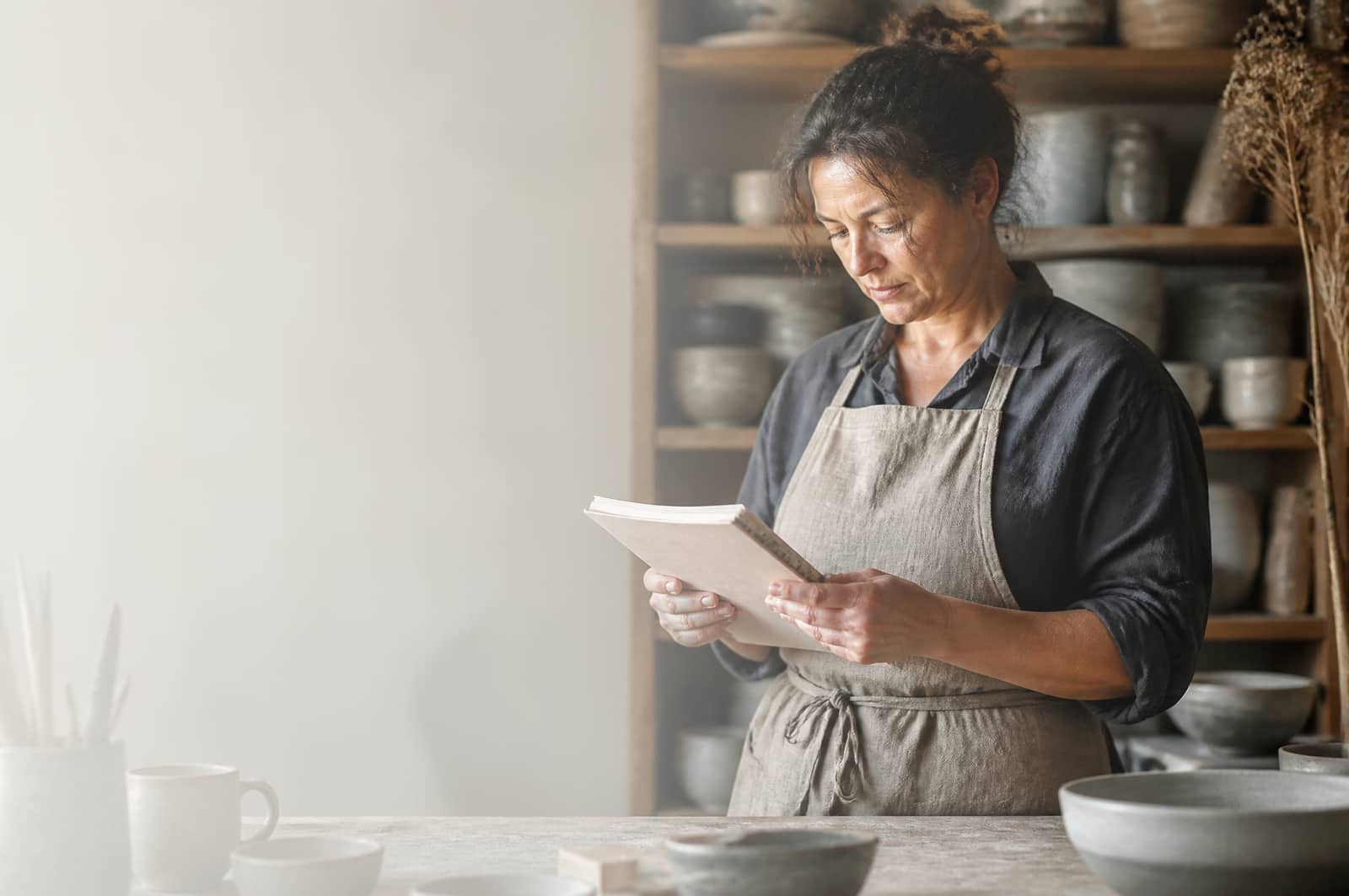 Dirigeante consultant son carnet dans son atelier